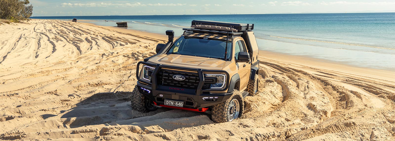 Ranger Super Duty driving in sand with a dr2 tray and canopy